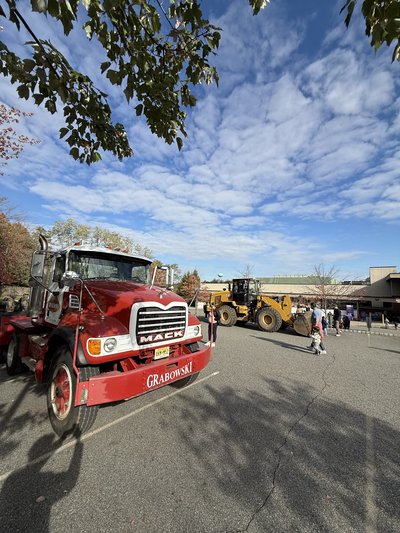 Mack truck and CAT loader staged at the touch-a-truck event lot.