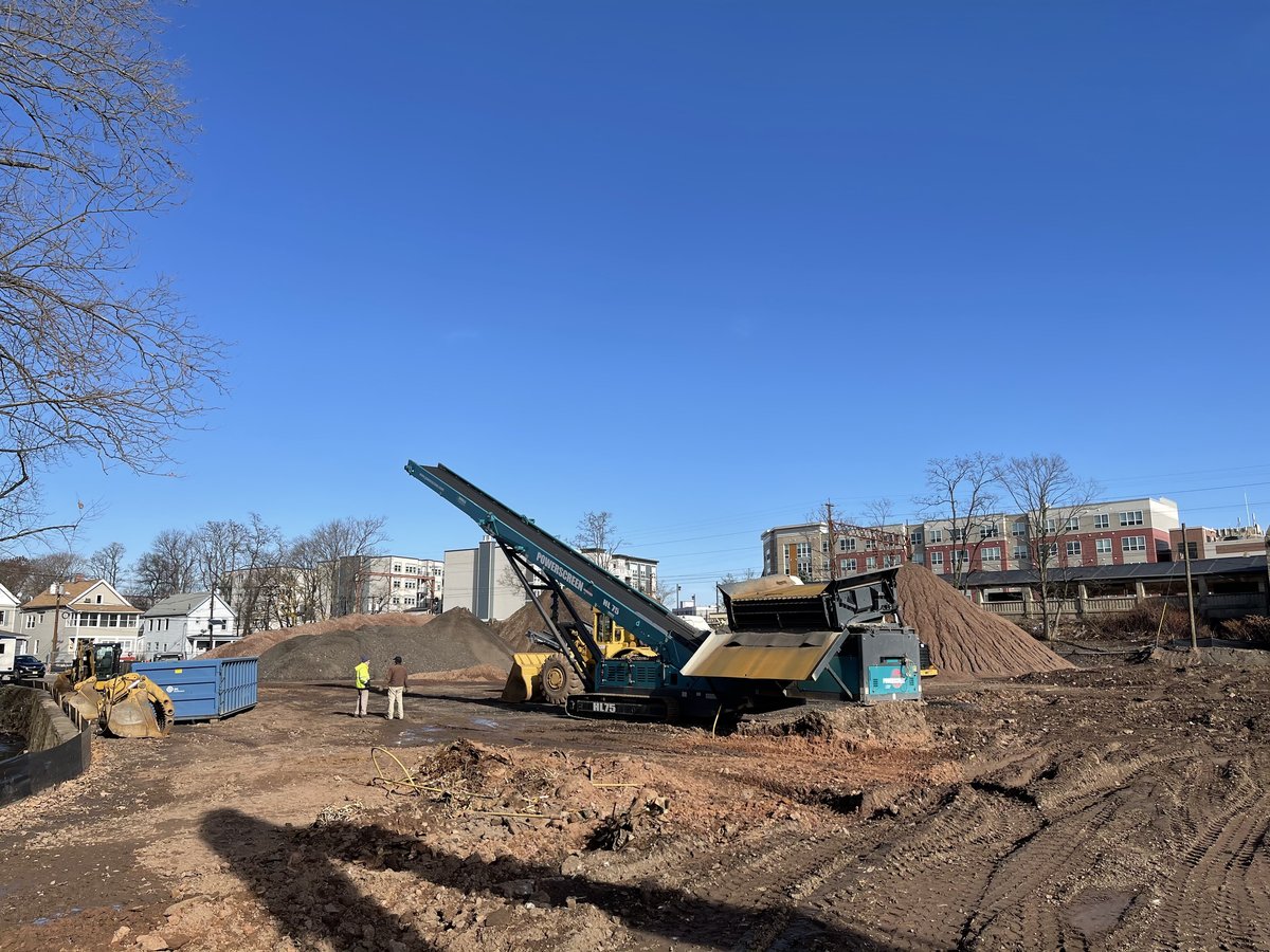 Soil screening conveyor and stockpile mounds on the 110 Washington site.